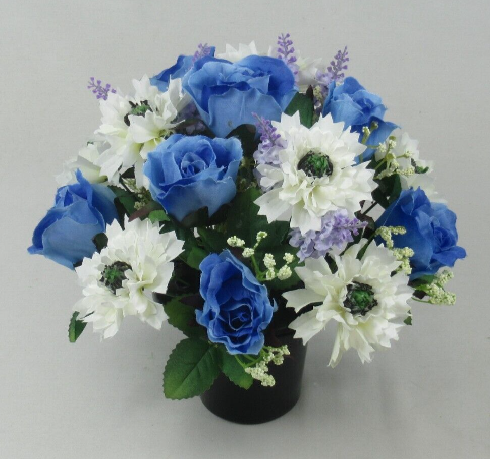 Artificial silk grave arrangement in black pot with blue roses, white flowers, and green filler