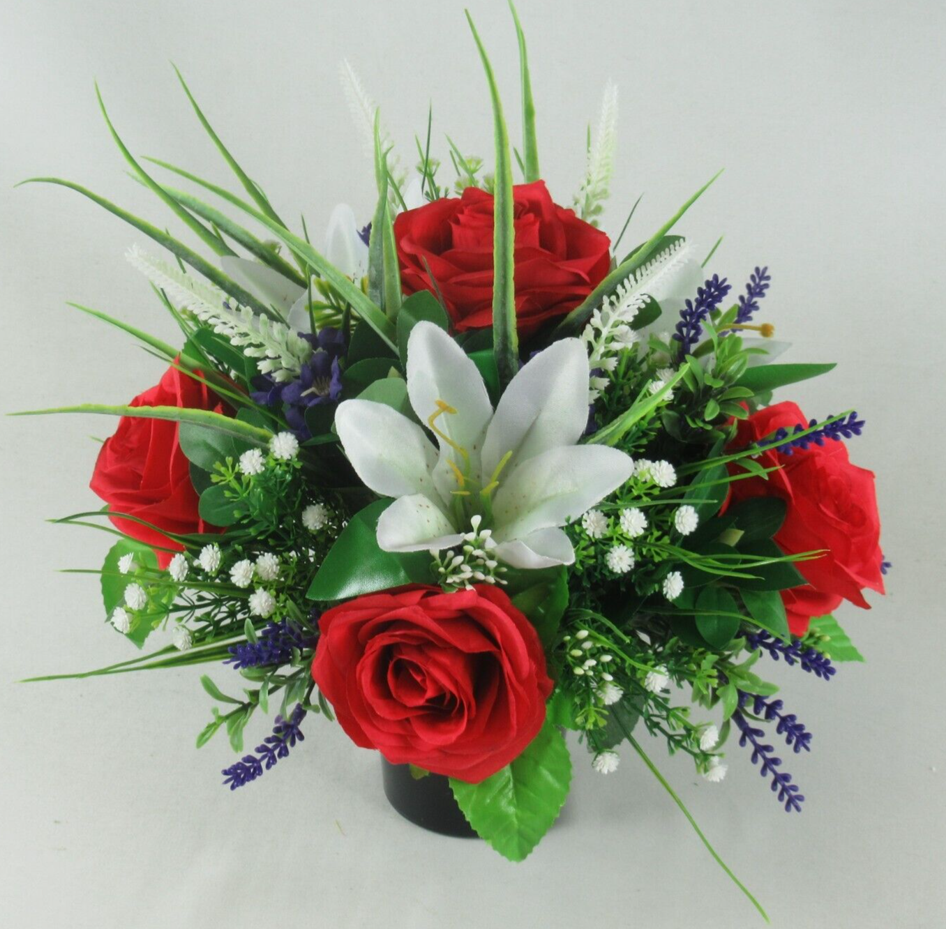 Artificial silk grave arrangement in black urn: red roses, white lilies, blue flowers