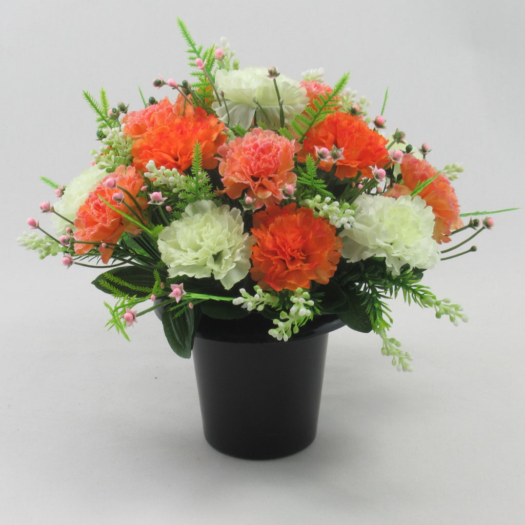 Artificial silk flower arrangement in black pot with orange, coral and white flowers