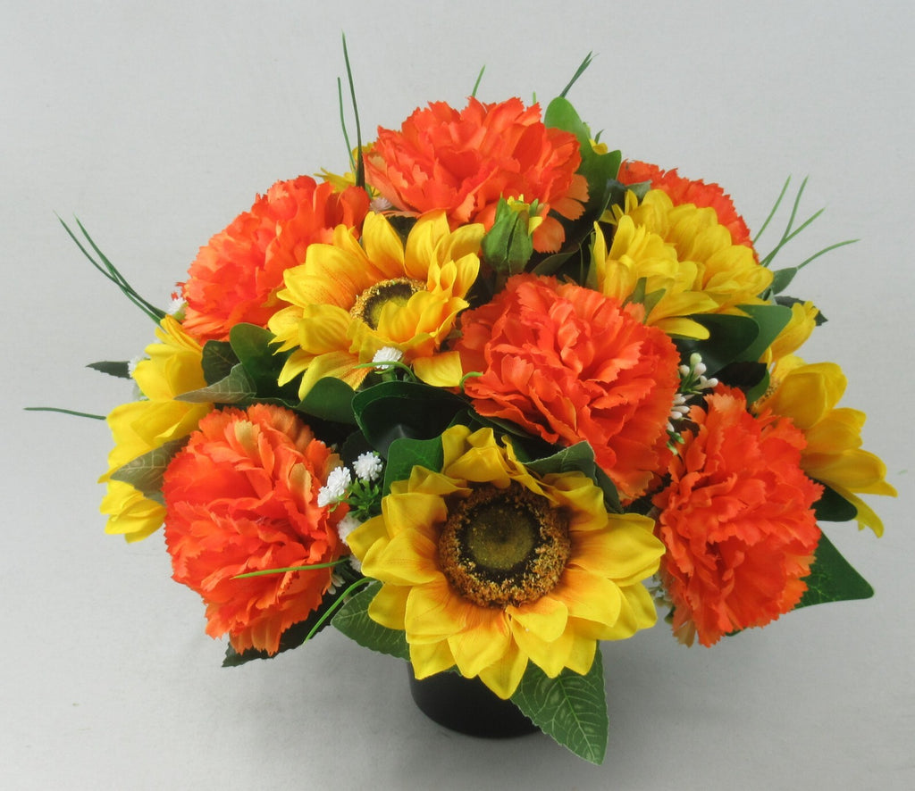 Cremation memorial pot grave arrangement with orange and yellow sunflowers and carnations