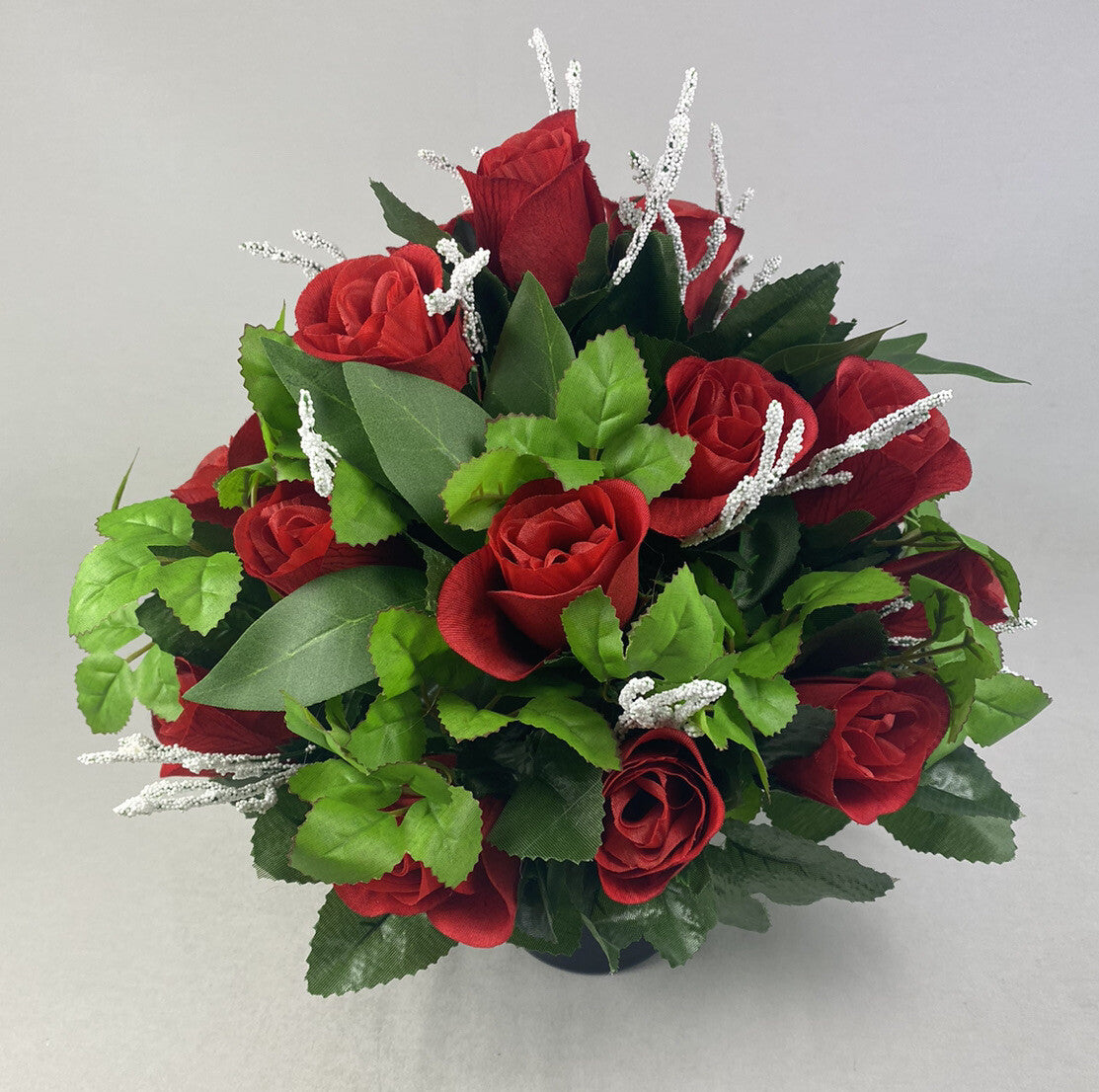 Large red rose artificial arrangement with green leaves and sparkling silver branch stems.