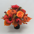 Autumn memorial gravepot arrangement: orange roses, red flowers, pumpkins and pomegranates in black pot