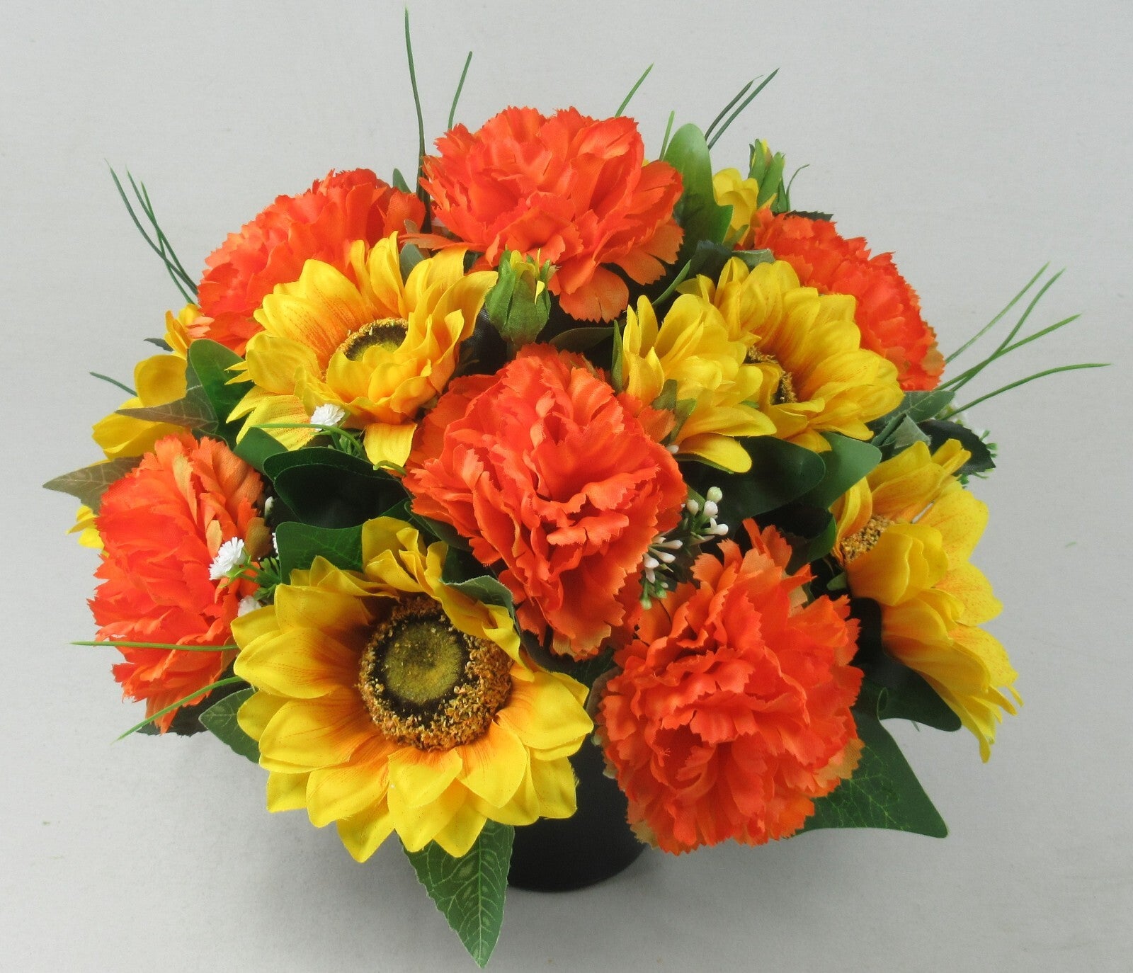 Artificial memorial grave pot arrangement with orange and yellow sunflowers and carnations