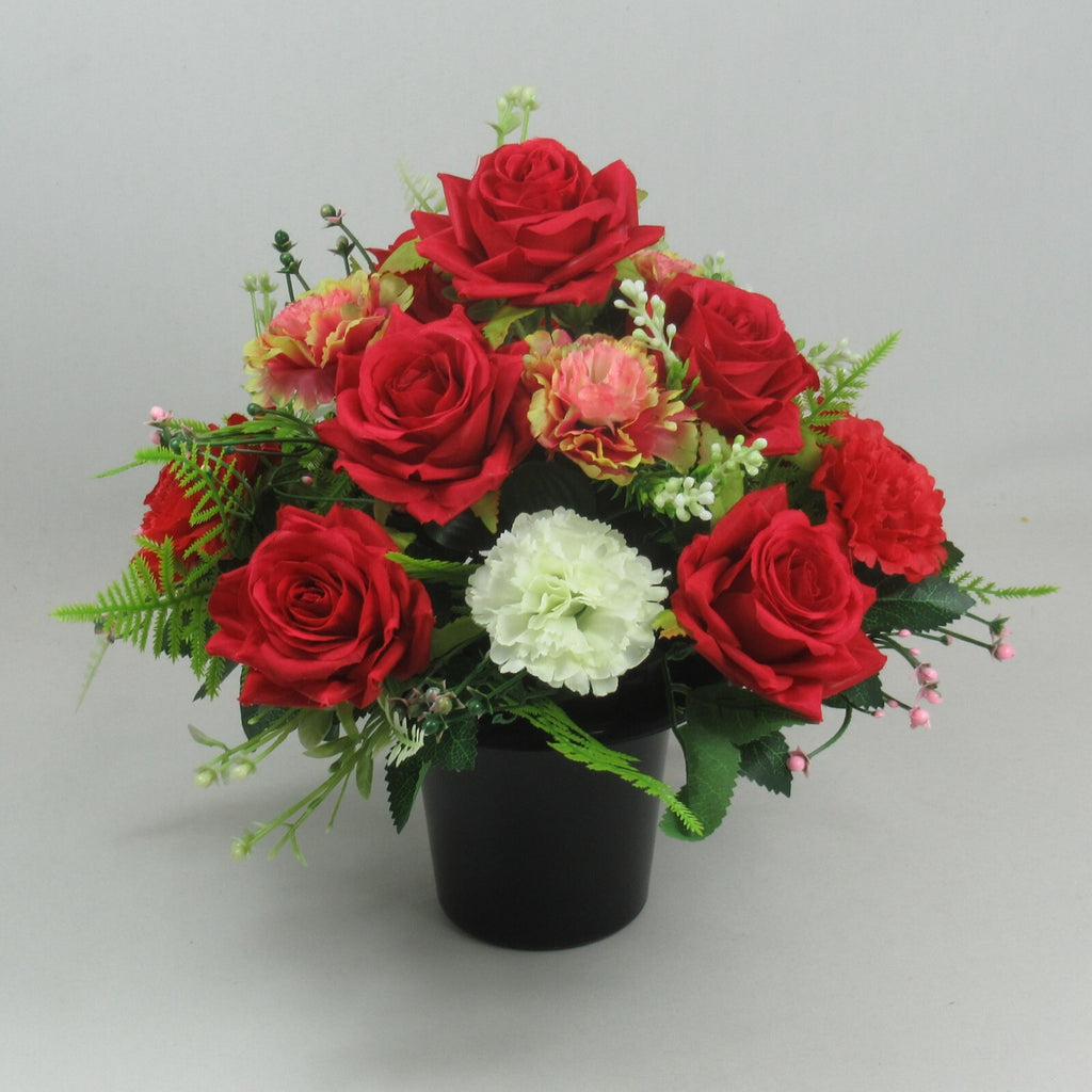 Artificial rose and mini carnation arrangement in black pot, red roses with pink and white blooms