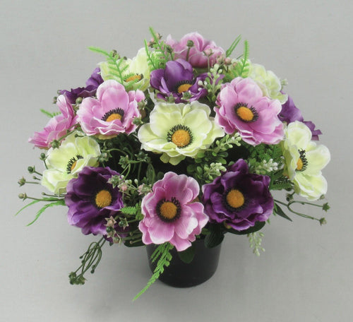 Grave flower arrangement in black pot with pink and purple anemones plus pale green blooms
