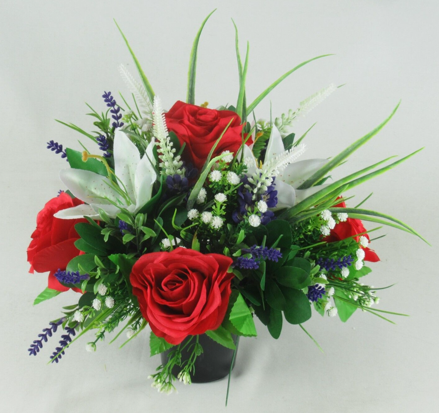 Black urn grave arrangement with red roses, white lilies, blue and white filler blooms