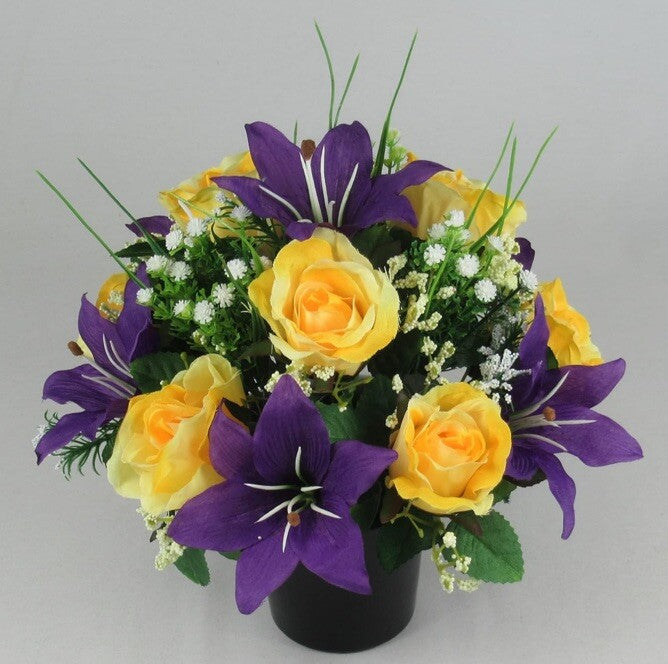Artificial grave arrangement with yellow rose blooms, purple lilies, green sprigs