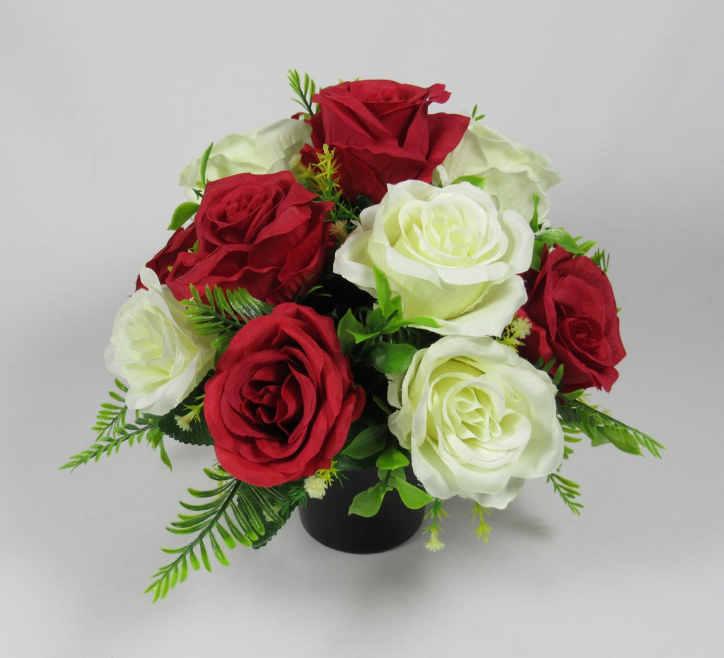 Artificial rose arrangement in black grave pot, open red roses with white roses and green leaves
