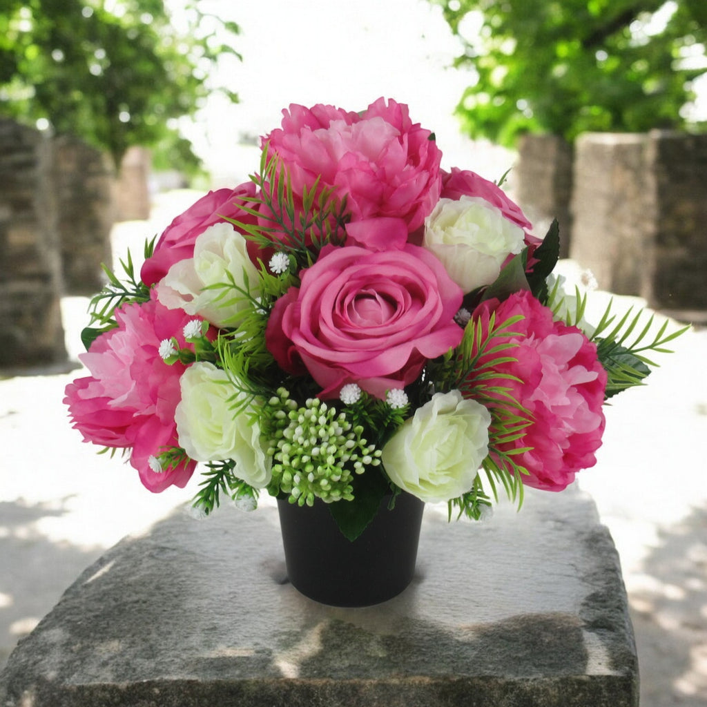 Pink and cream artificial rose, peony and greenery grave memorial bouquet in black vase