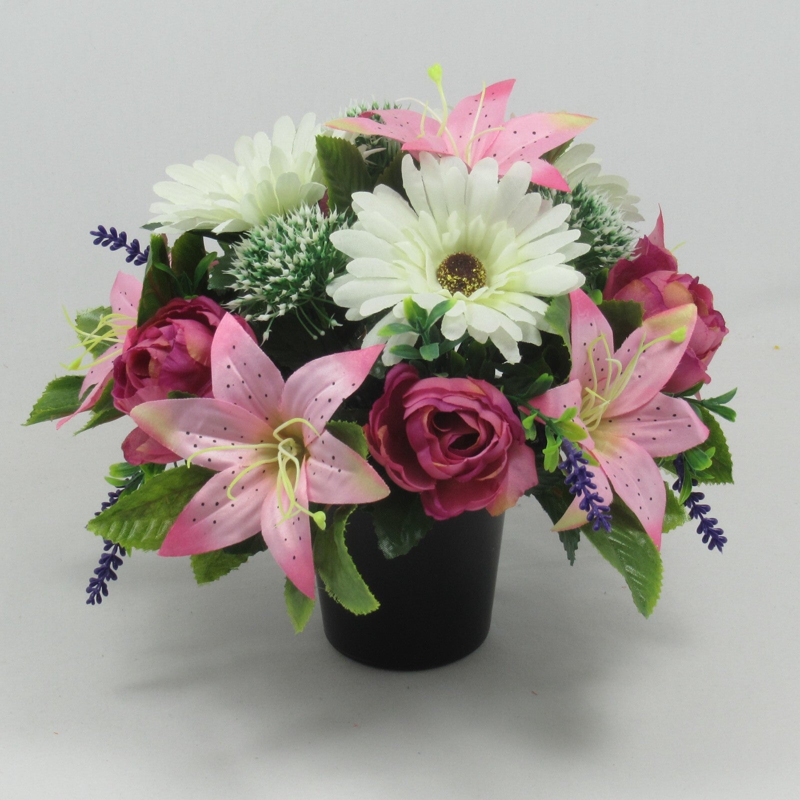 Memorial grave artificial flower arrangement with white/pink lilies, roses, lavender spikes.