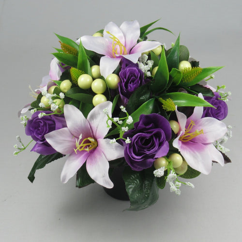 Front view grave flower arrangement: purple roses, lilac lilies, green foliage, light-green berries
