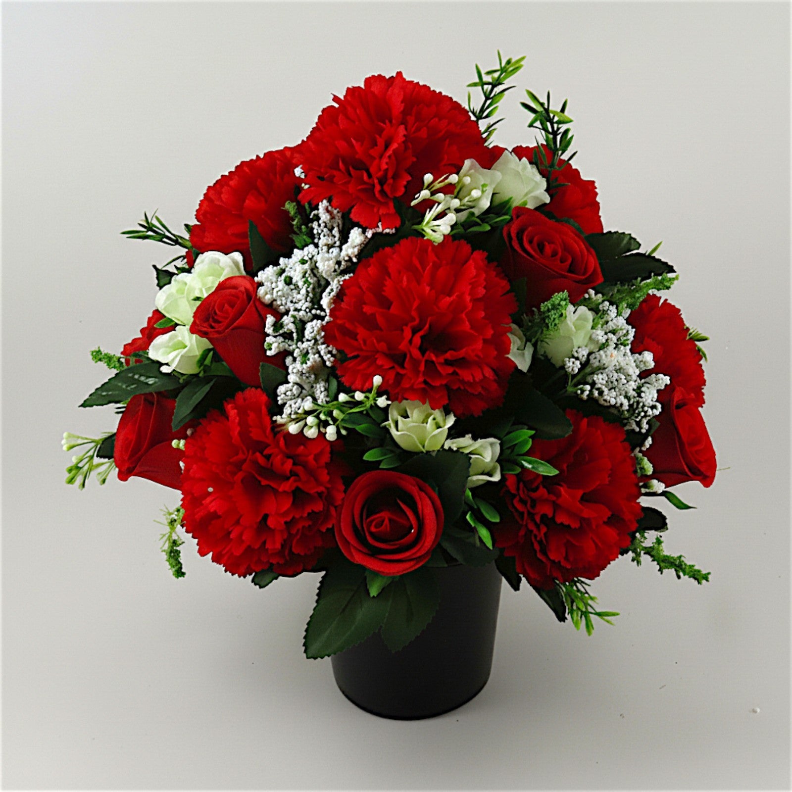 Artificial red rose & carnation memorial arrangement with white filler, in black pot