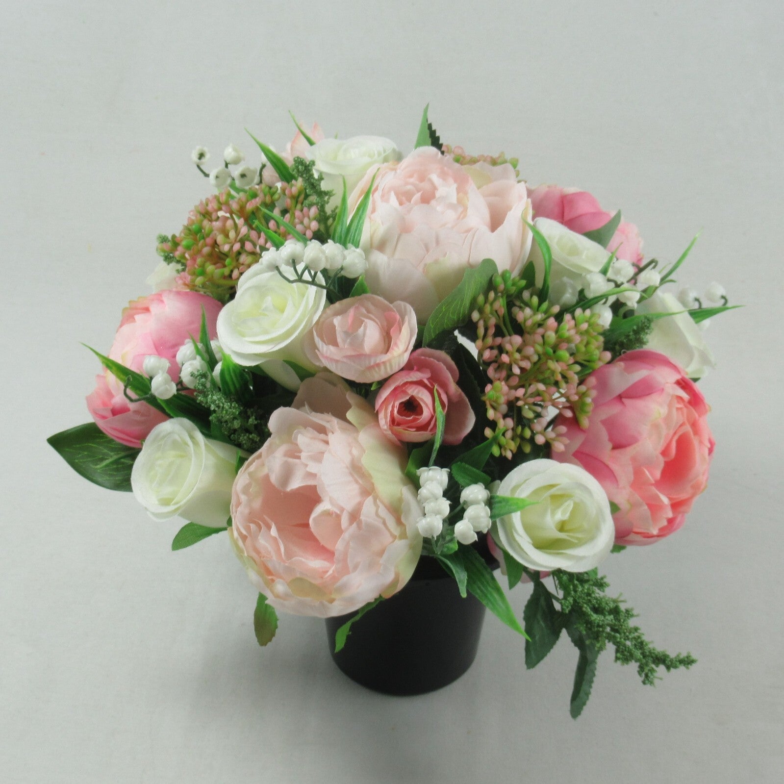 Artificial silk grave bouquet with large pink and white roses, green leaves, black pot