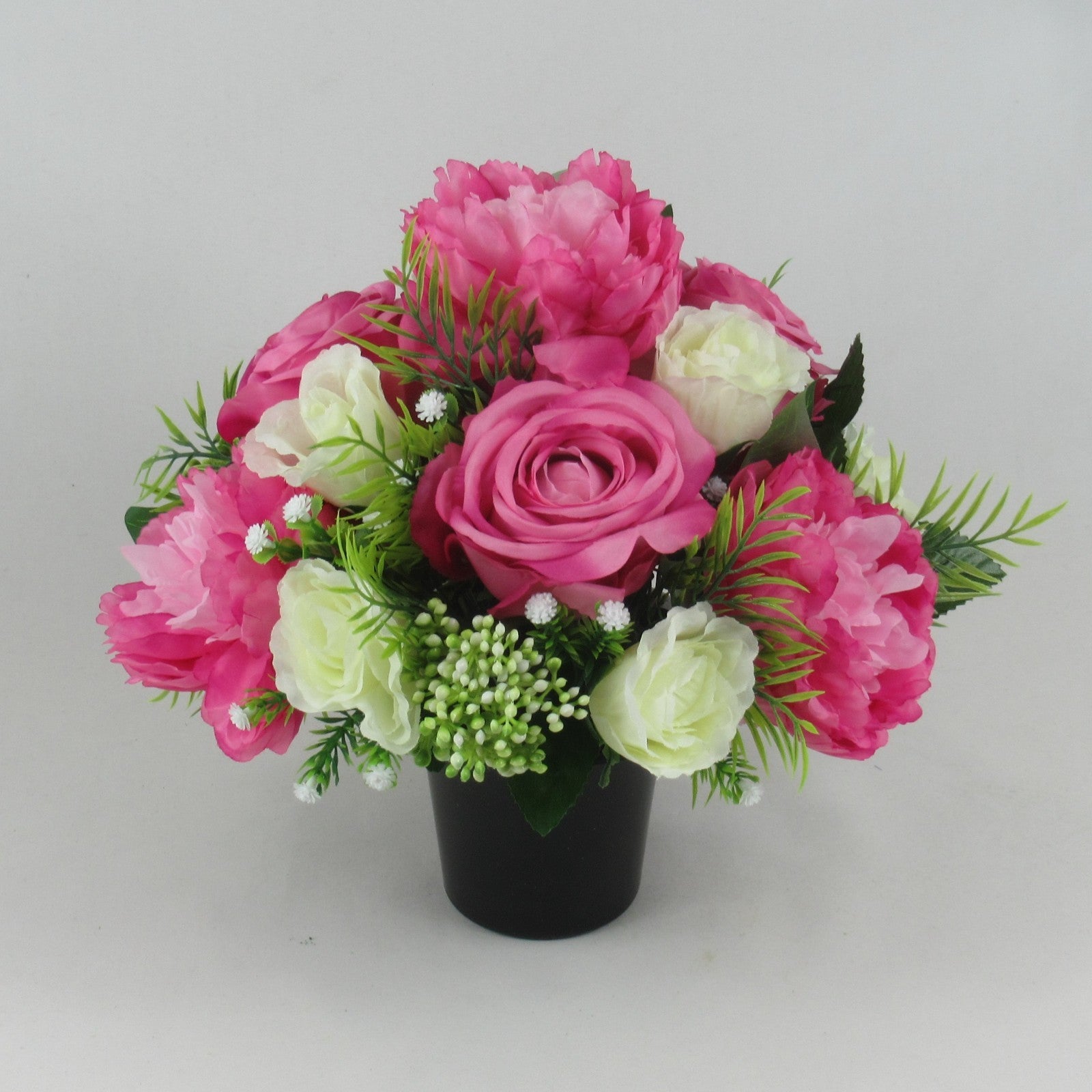 Front-facing pink and cream artificial rose and peony grave memorial bouquet in black vase
