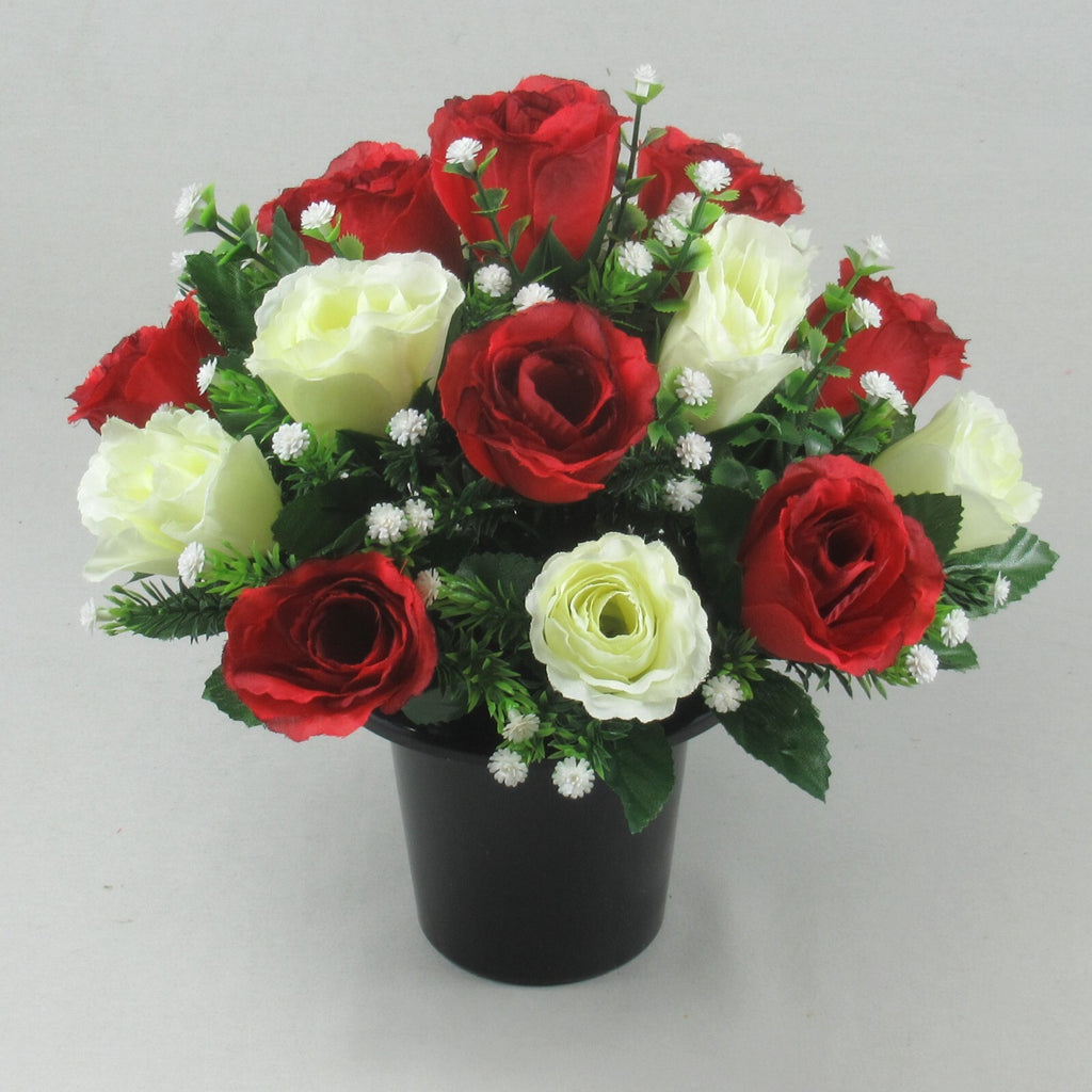 Angled artificial rose grave arrangement with red and ivory blooms in black pot
