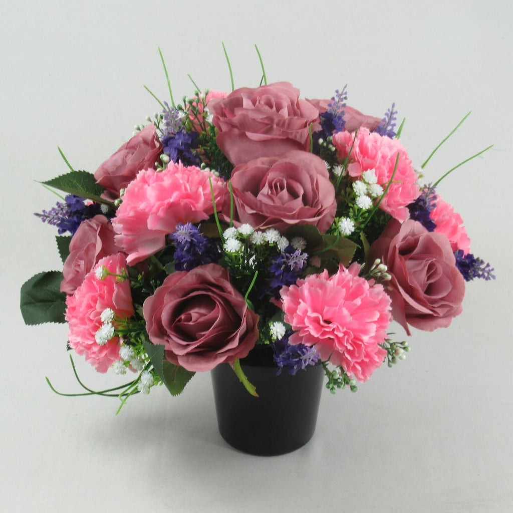 Artificial silk memorial cremation pot arrangement with pink and mauve roses, purple accents