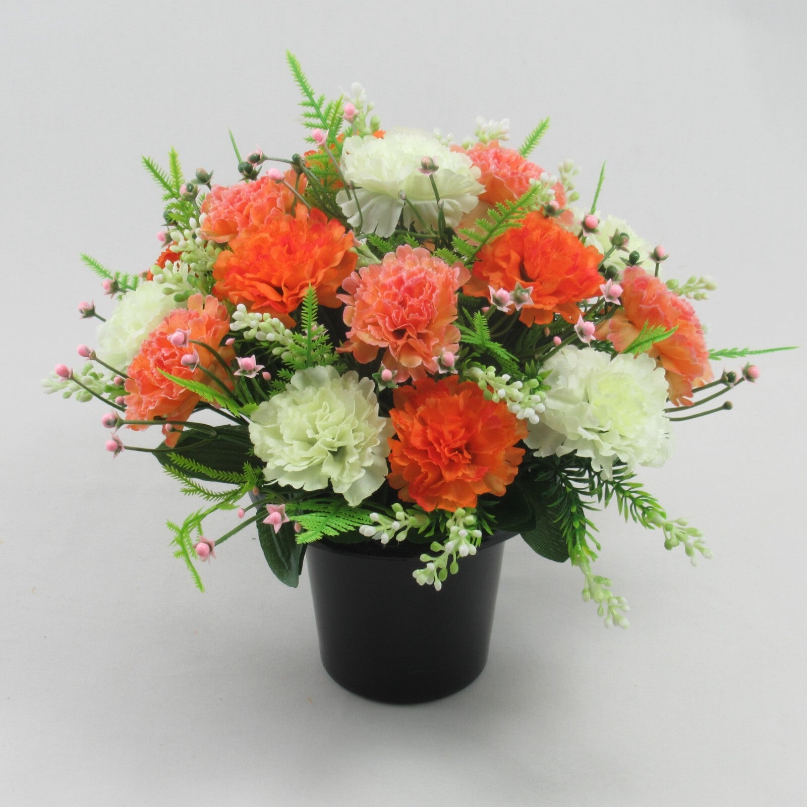Autumnal artificial flower grave pot display, orange and cream rosette blooms with greenery