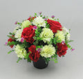 Artificial grave crem pot arrangement with red and white flowers, purple sprigs in black pot