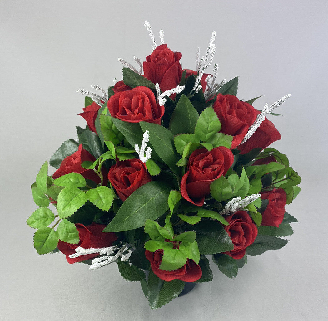 Large artificial floral arrangement: red roses, bright green leaves, silver twig sprays.
