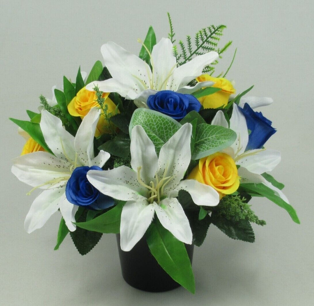 Artificial silk grave bouquet in black pot featuring white lilies, blue roses, yellow roses, greenery