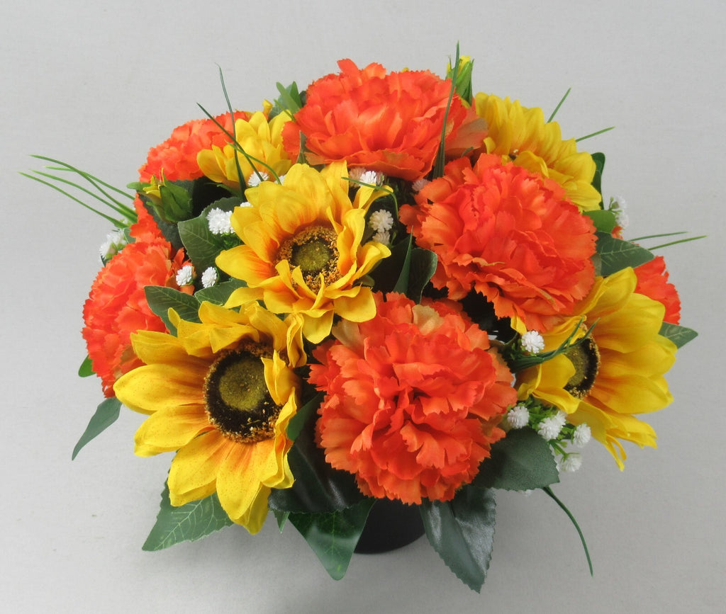 Artificial memorial grave pot bouquet with orange and yellow sunflowers, carnations, and white sprigs