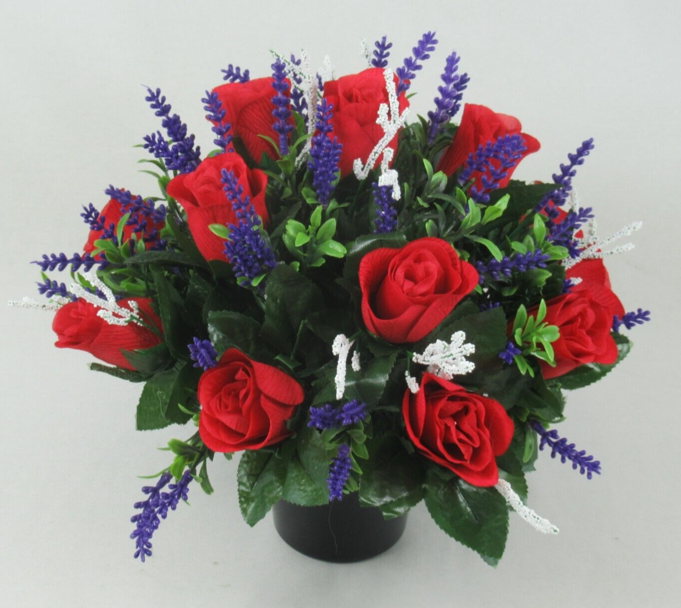 Angle view of red rose artificial memorial grave arrangement in black pot with purple and white sprigs