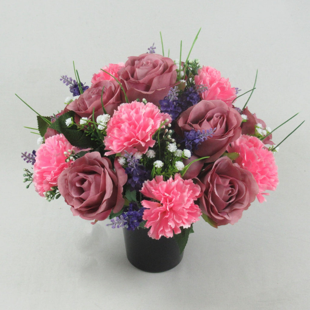 Artificial silk memorial cremation pot bouquet with pink carnations, mauve roses, and purple flowers