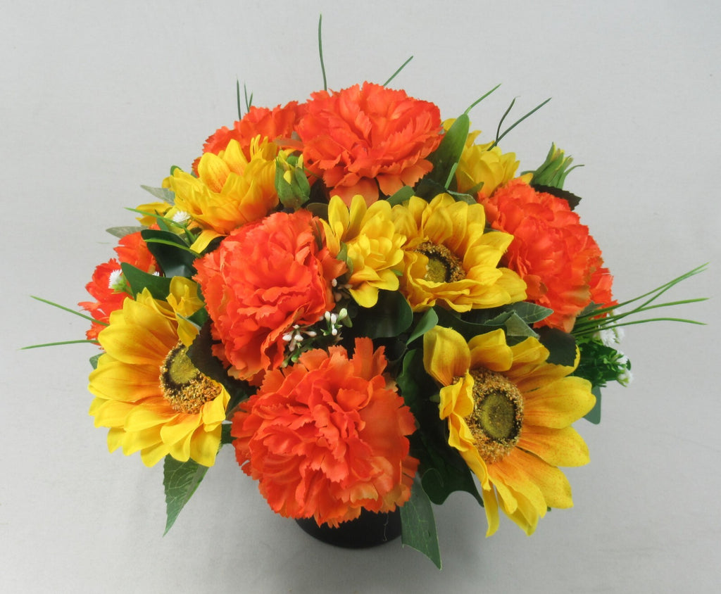 Artificial flower memorial pot with large orange and yellow blooms and dark green foliage