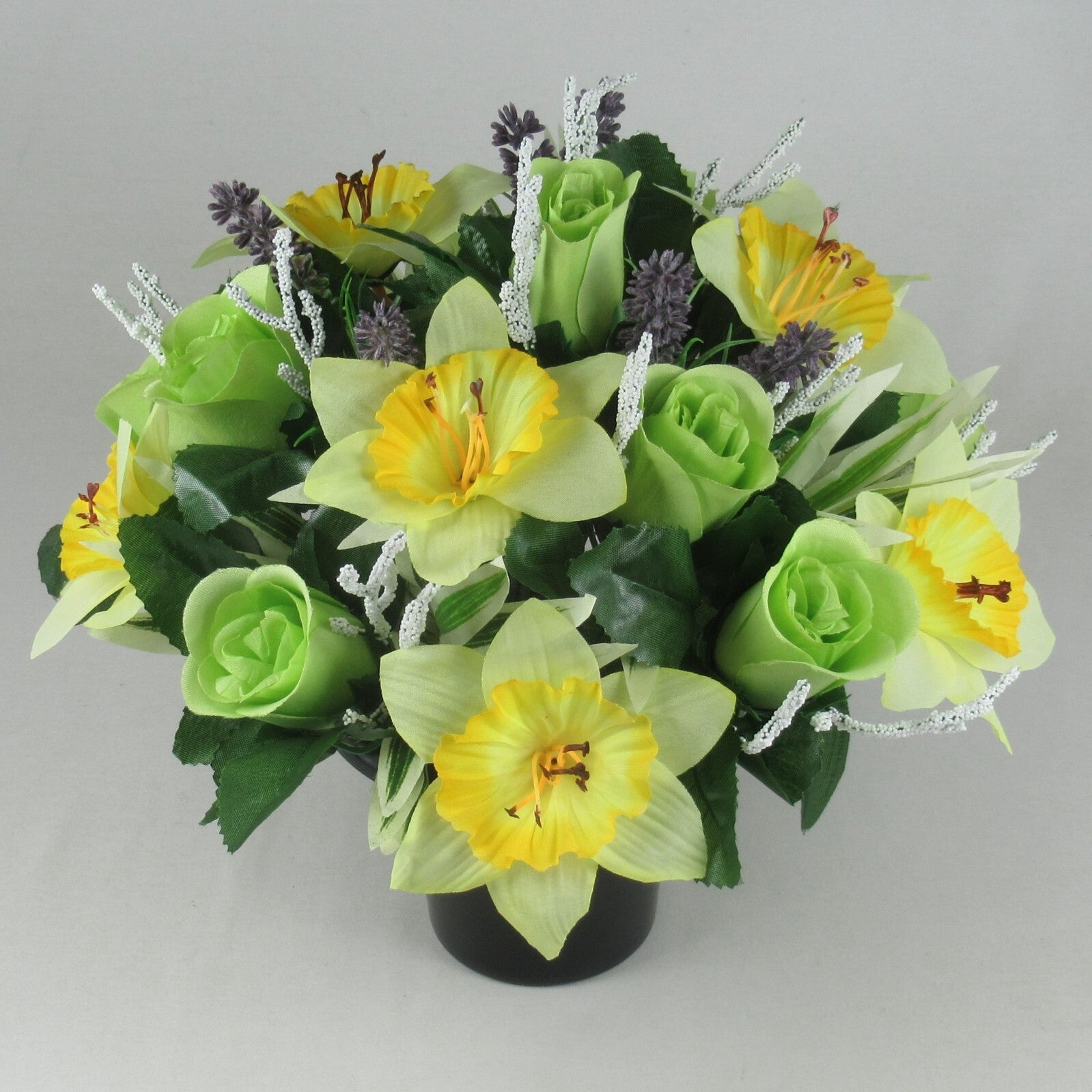 Front view artificial grave pot flowers: yellow daffodils, green roses, purple buds, white tinsel stems