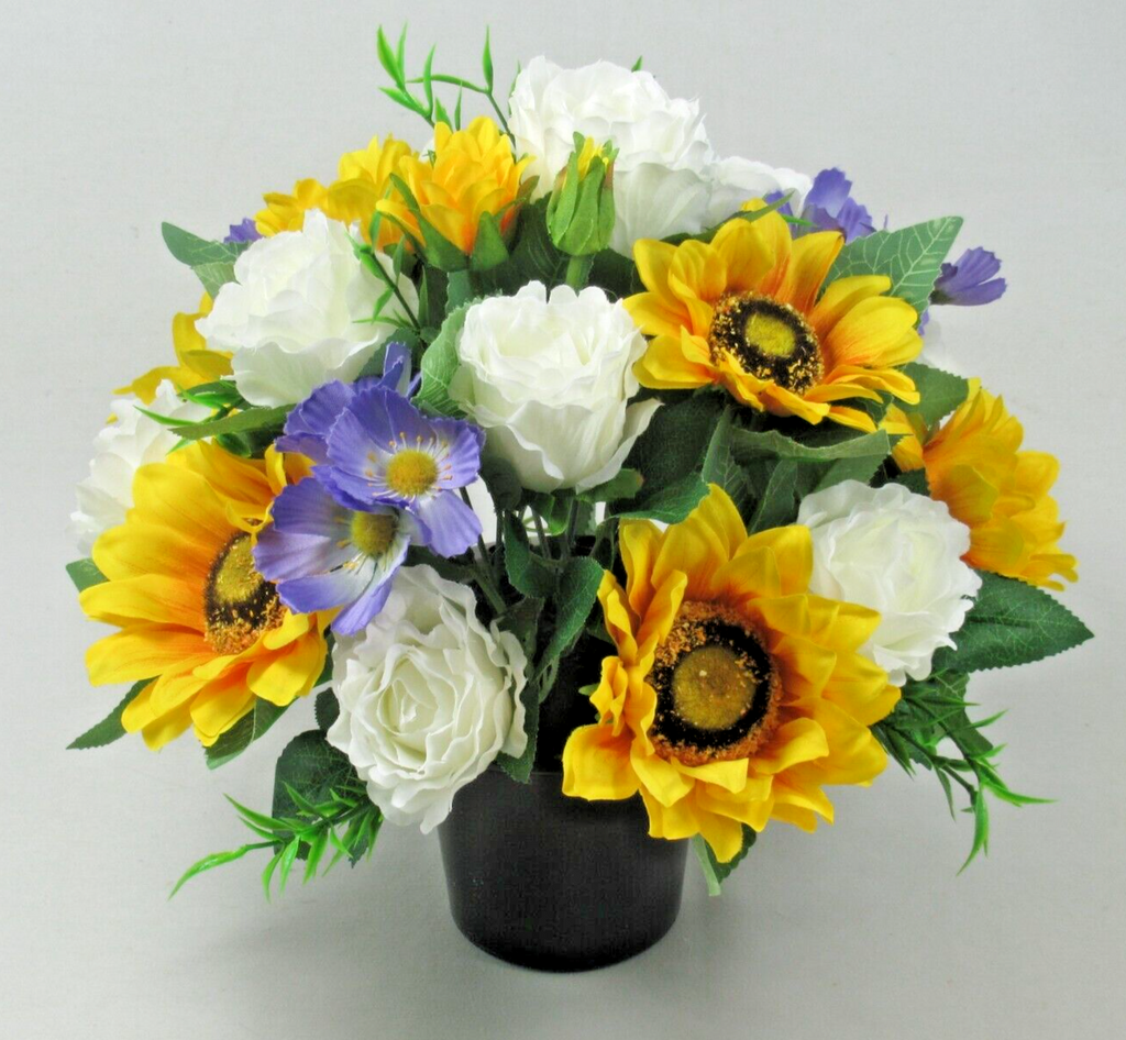 Artificial silk grave pot arrangement: yellow sunflower heads, white roses, blue blooms, green leaves