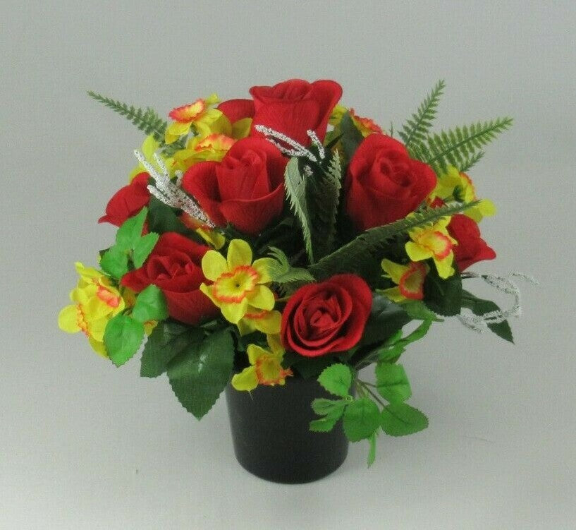 Front view silk flowers: red roses and yellow blossoms with green leaves in black pot