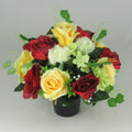 Artificial grave bouquet in black vase: yellow and red roses with white and pale green blooms