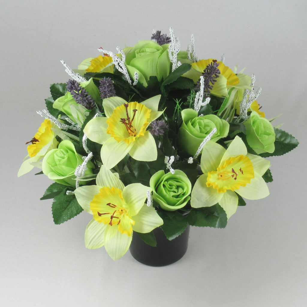 All-round grave arrangement with yellow daffodil blooms, green roses, purple accents in black pot
