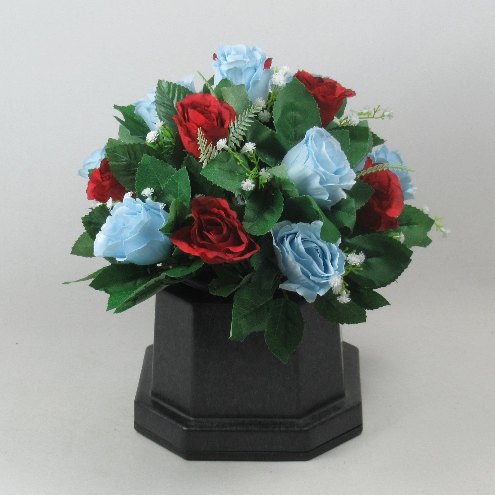 Artificial grave rose arrangement with red and light blue roses on a black square base