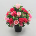 Memorial artificial floral arrangement in black pot, pink roses and red-pink chrysanthemums