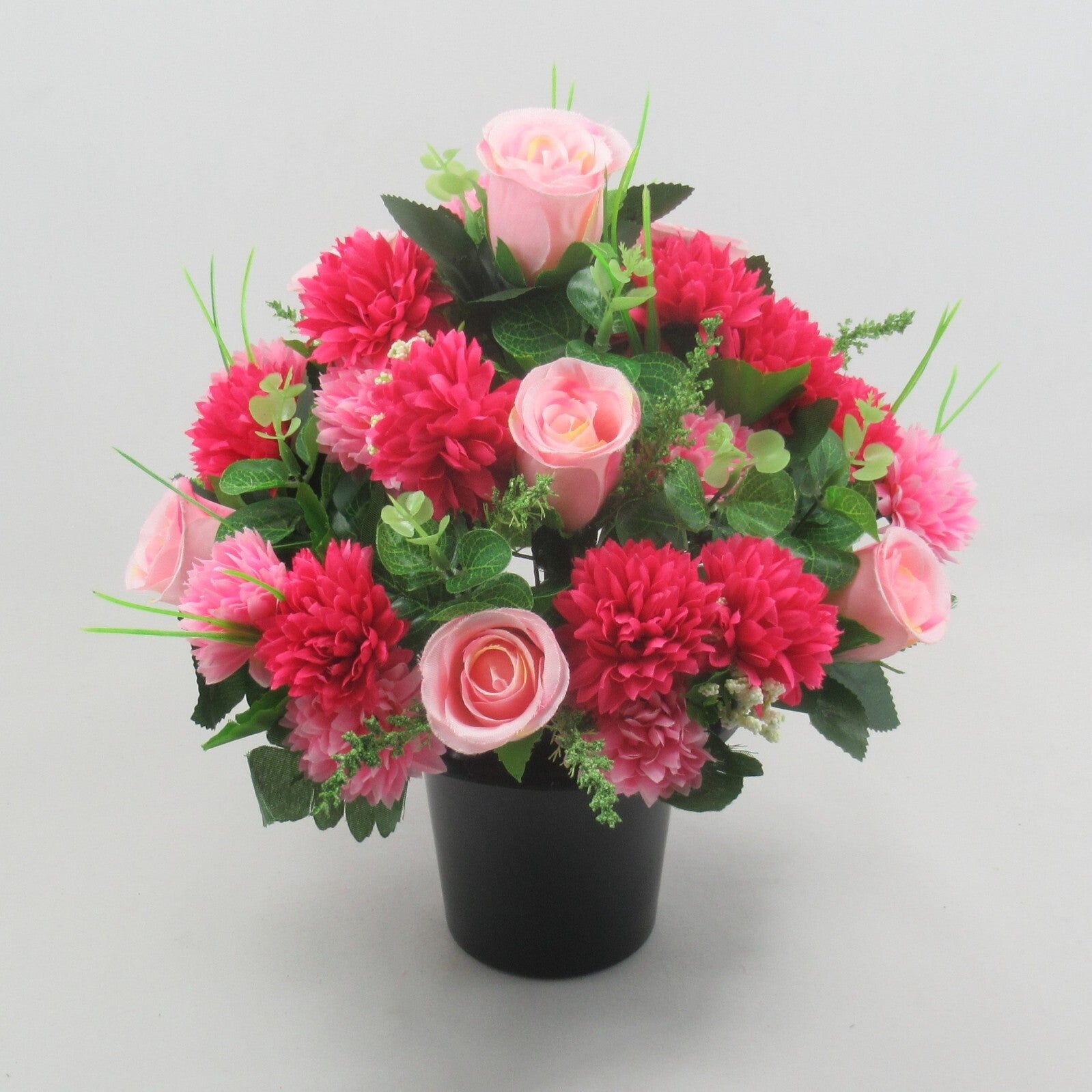 Memorial artificial floral arrangement in black pot, pink roses and red-pink chrysanthemums