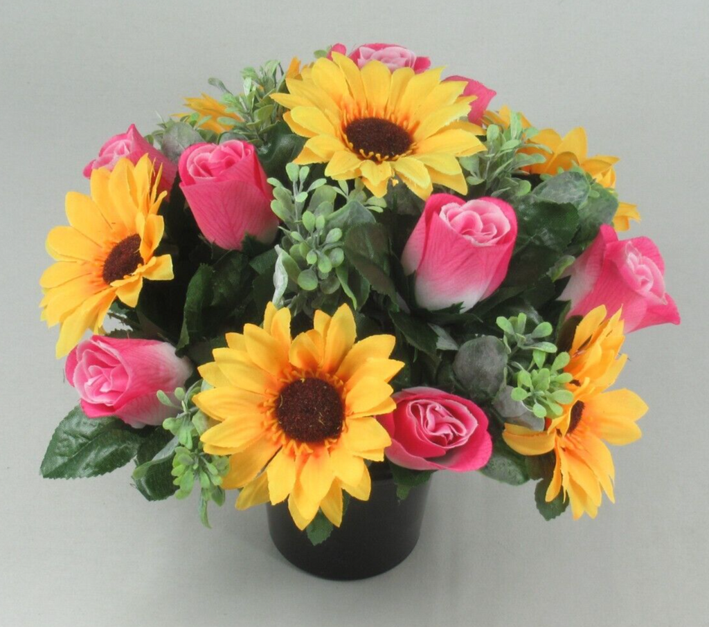 Black crem pot arrangement with artificial yellow sunflowers, pink roses, and green leaves
