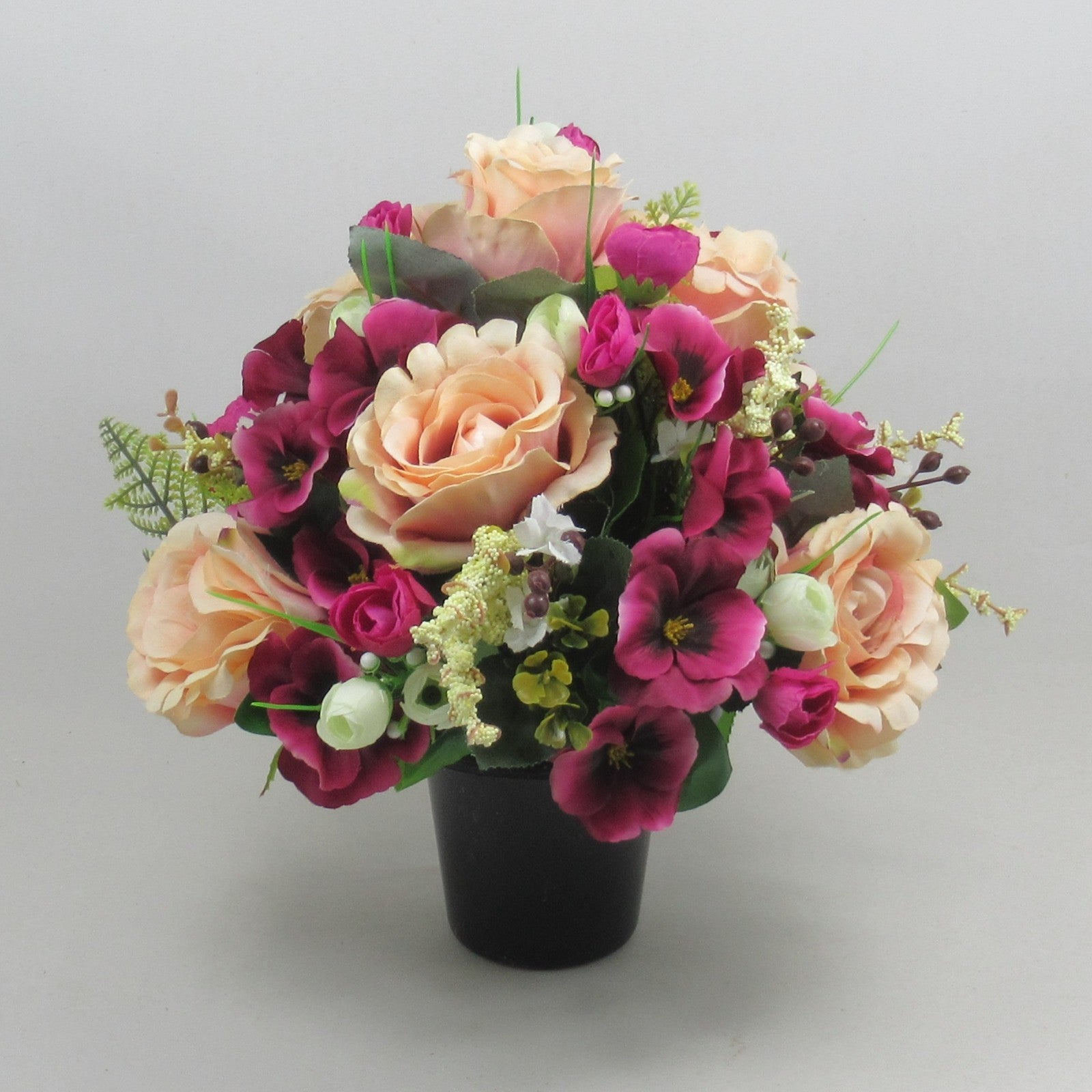 Large artificial memorial flowers in black pot: cream roses & magenta blossoms