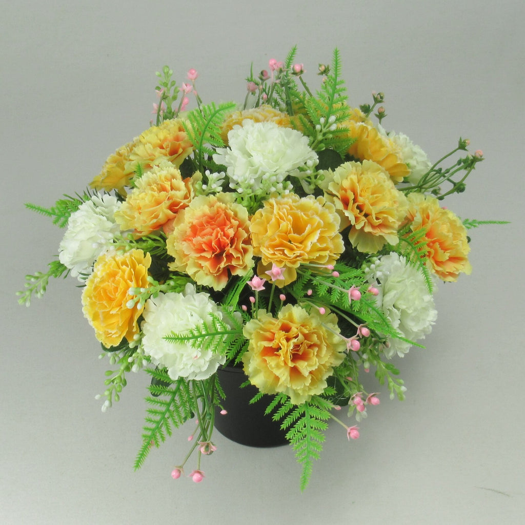 Artificial silk flower grave arrangement in black crem pot, orange, yellow, white blooms