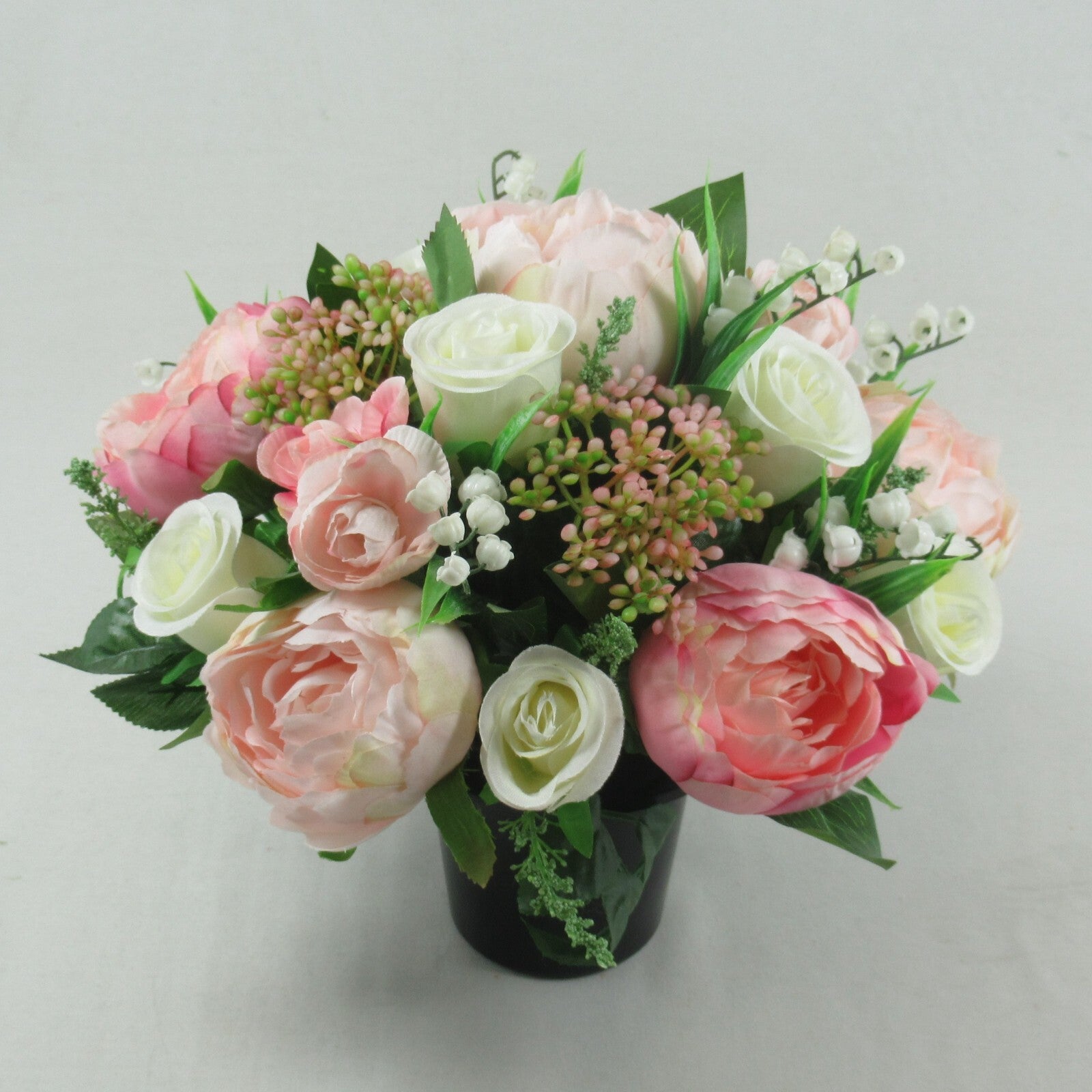 Artificial silk flowers memorial grave arrangement, pastel pink and white roses in black pot