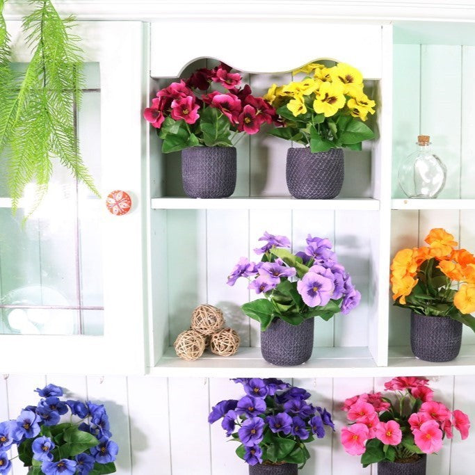 Artificial silk pansy bunch with mixed red, yellow, and purple blossoms and green leaves