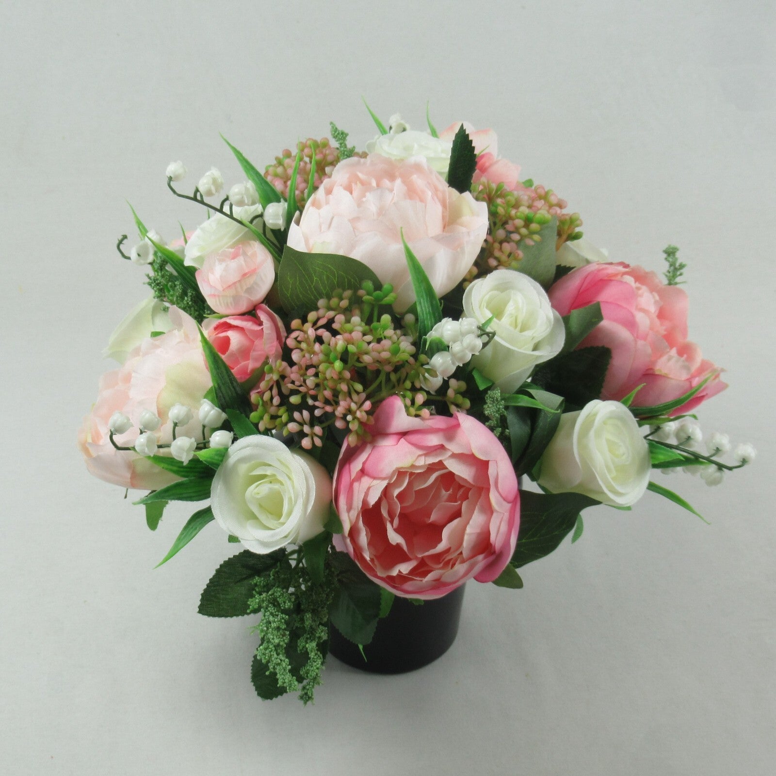 Artificial silk flower grave arrangement in black pot, pale pink and white blooms