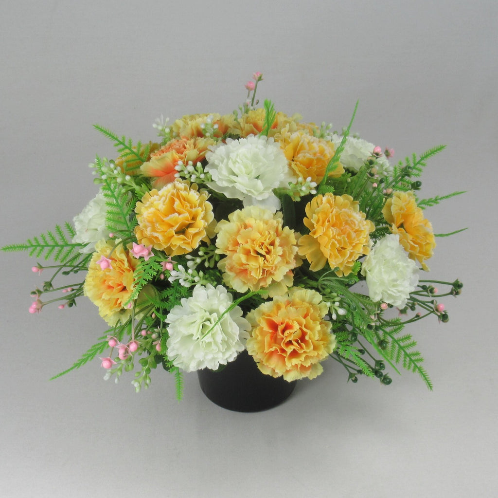 Front view artificial silk flowers in black crem pot, yellow, white and orange blooms