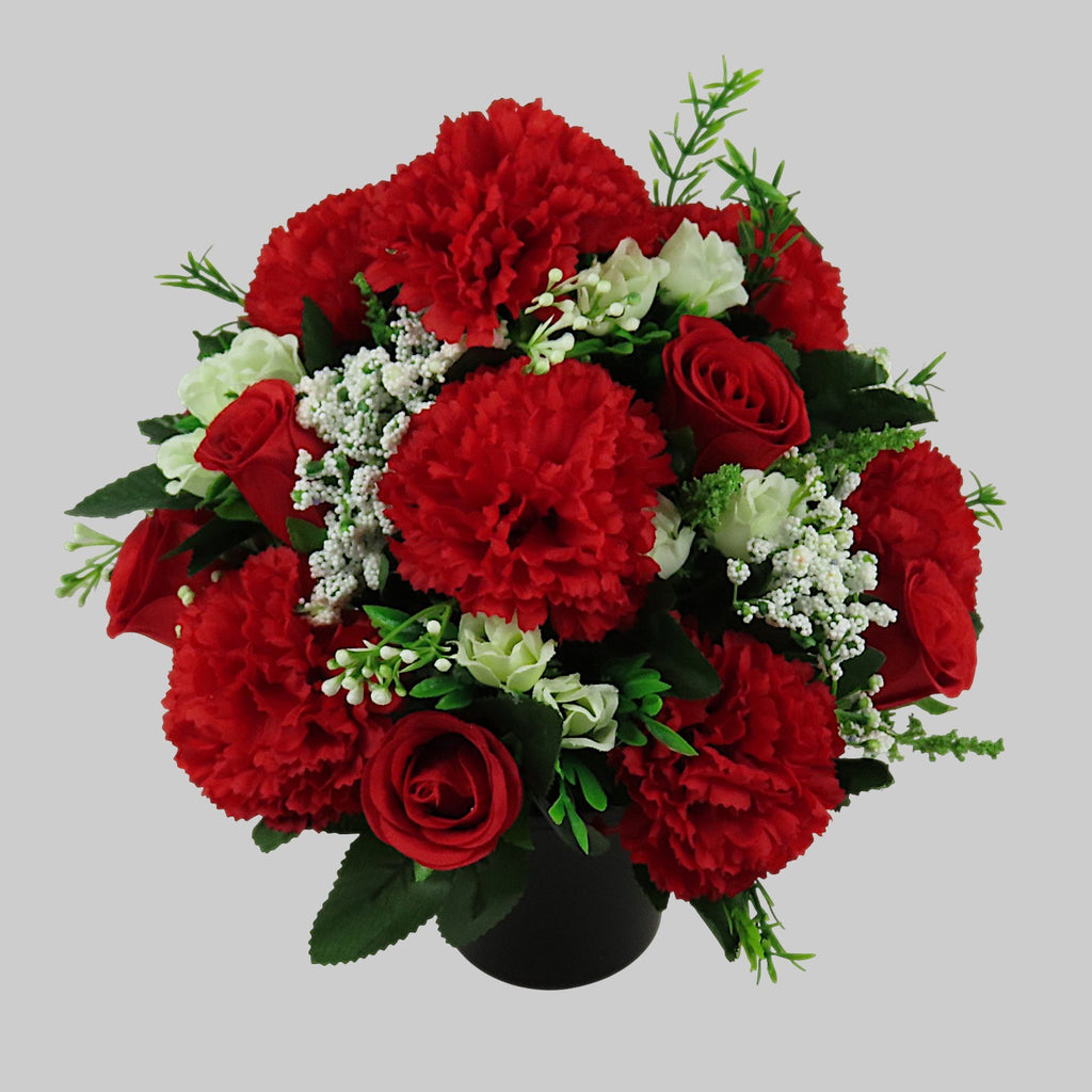 Red rose, carnation, and white filler artificial grave flower bouquet in black vase