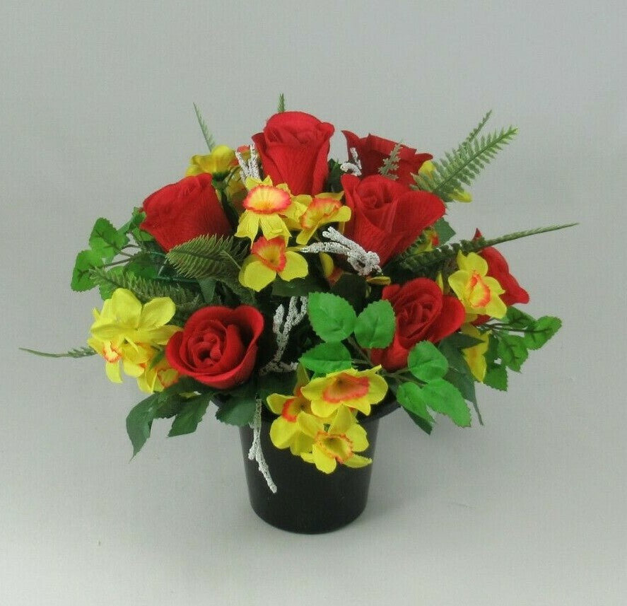 Artificial red rose and yellow flower memorial arrangement in black cremation pot