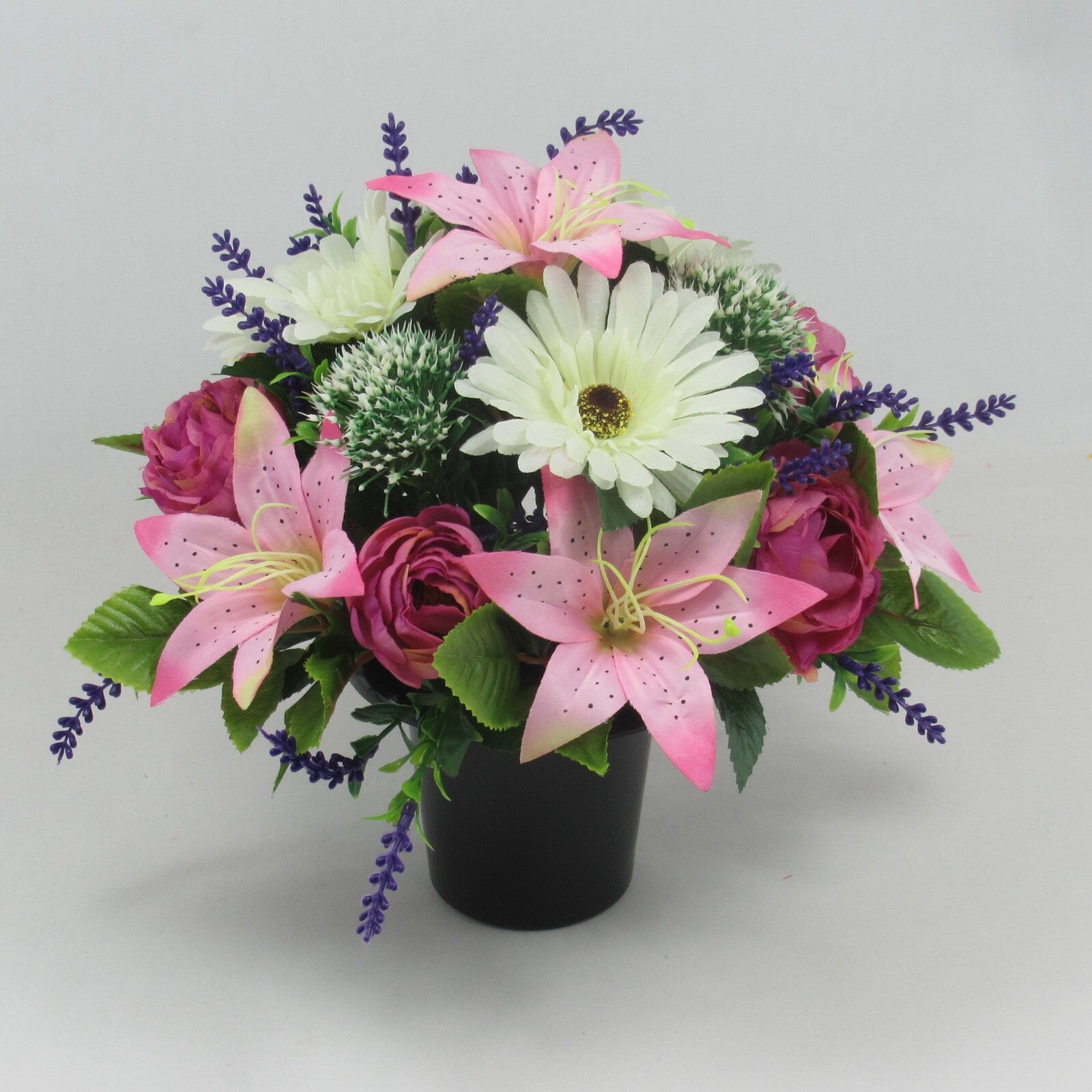 Memorial grave artificial pot with pink lilies, roses, white flowers, lavender sprigs.