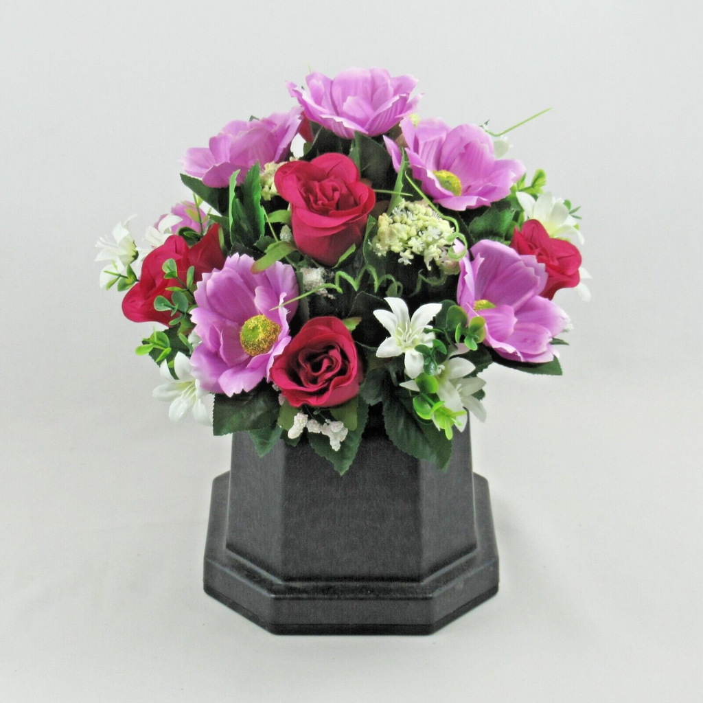 Hexagonal black base with purple and red artificial silk flowers and white blossoms