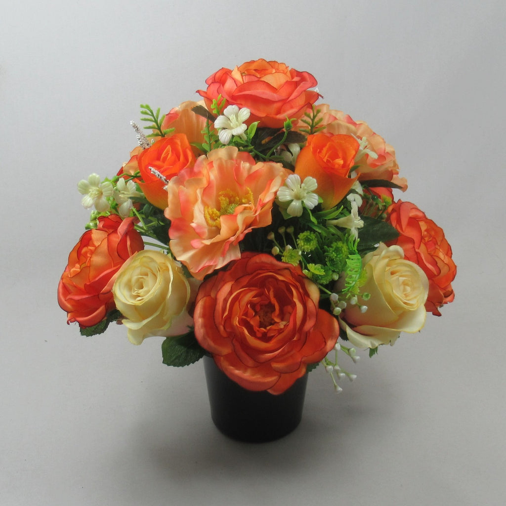 Artificial autumn rose and poppy arrangement in a black pot, orange red and cream blooms