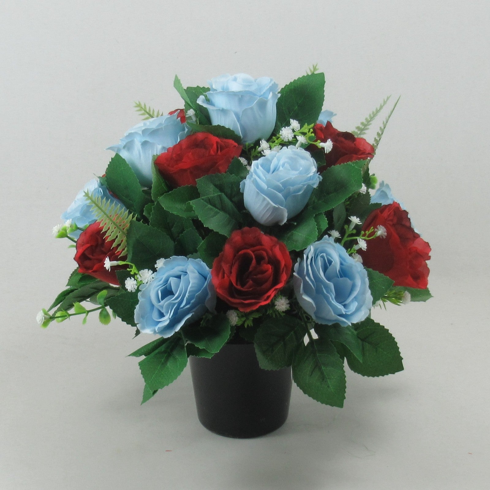 Artificial grave rose arrangement with red and light blue blooms in a black pot