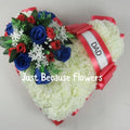 Heart-shaped artificial grave tribute wreath with red and blue flowers and white 'Dad' ribbon